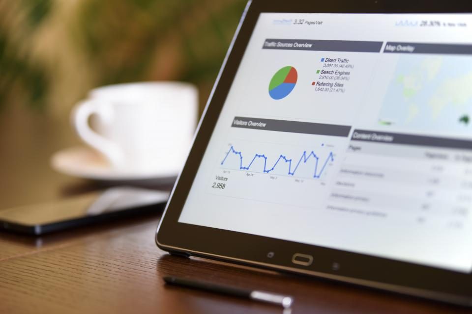 Analytics dashboard with traffic and conversion charts open on a laptop