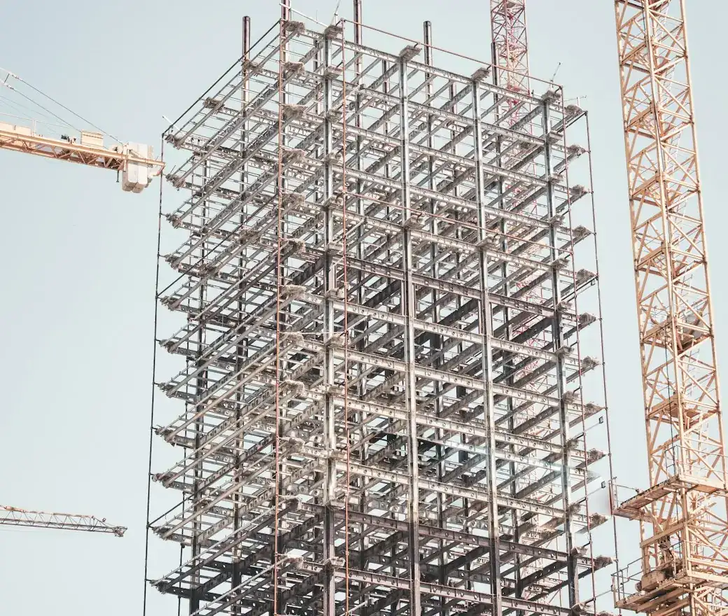 A building frame going up beside a tower crane