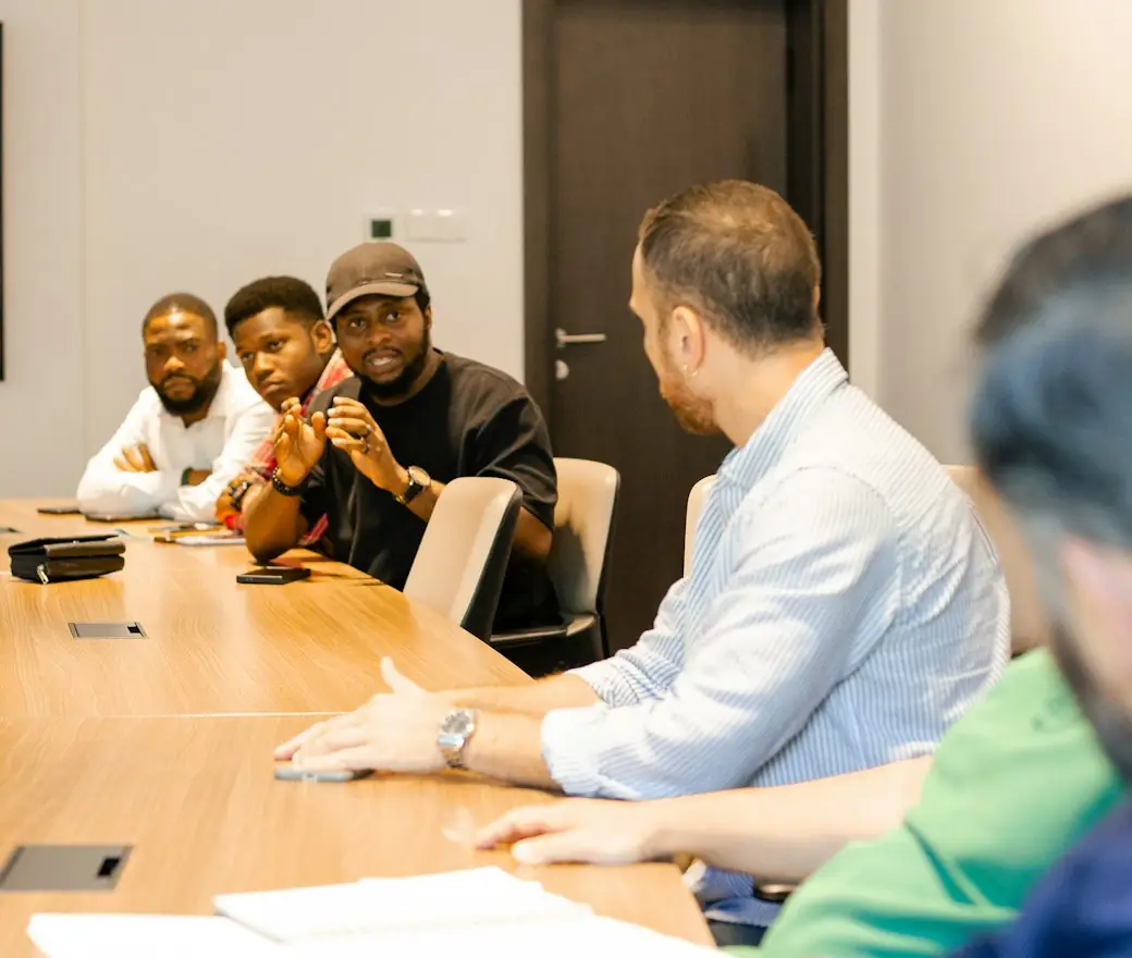 A sales team in a meeting around a table with laptops
