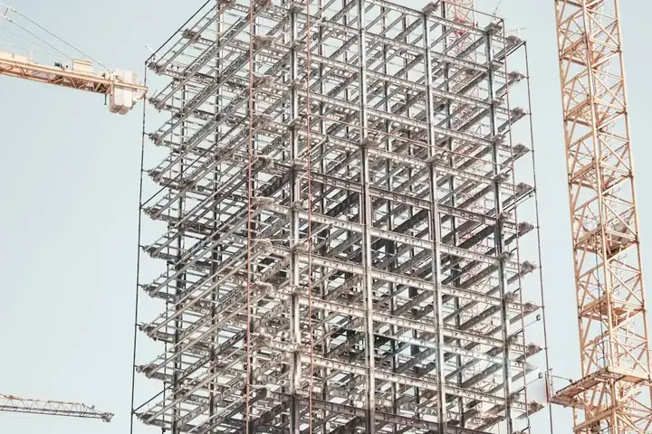 A building frame going up beside a tower crane