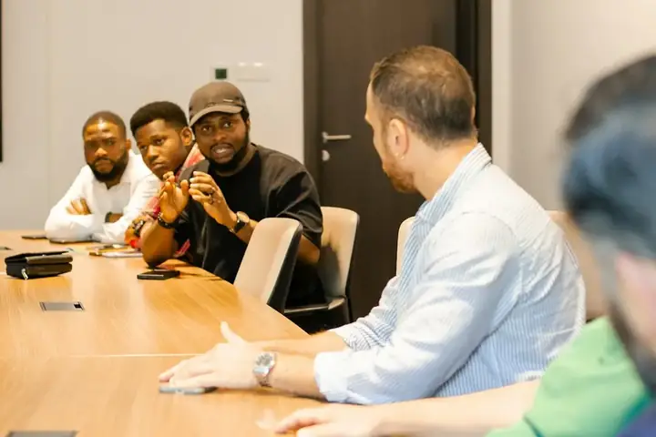 A sales team in a meeting around a table with laptops