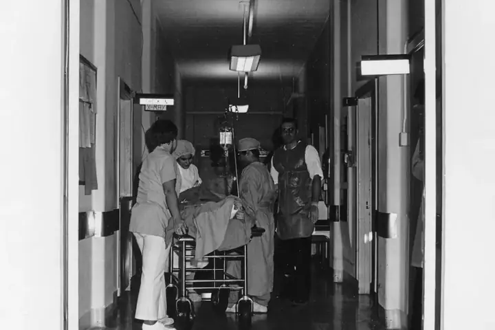 Medical staff moving a patient down a hospital hallway